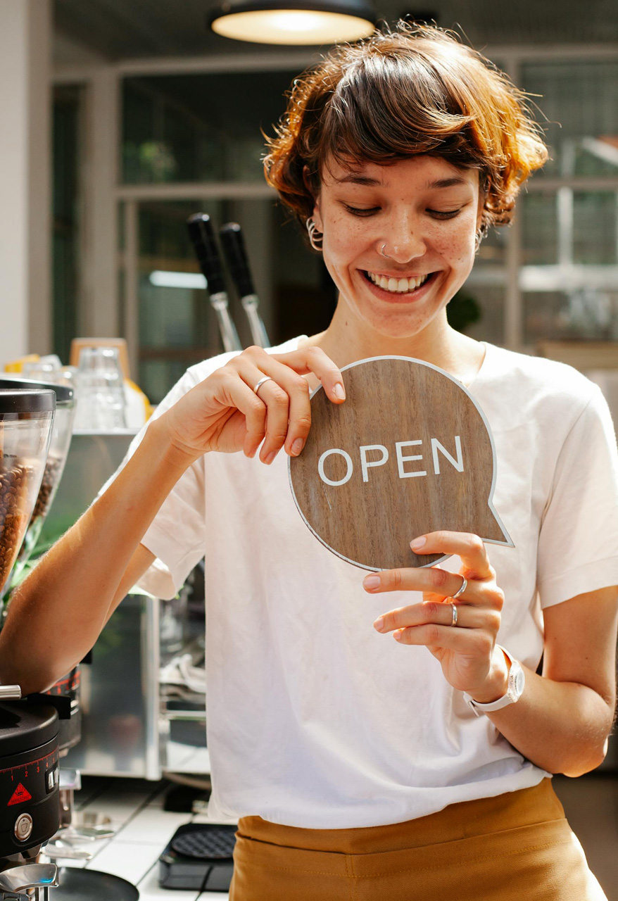 Woman holding a shop open sign